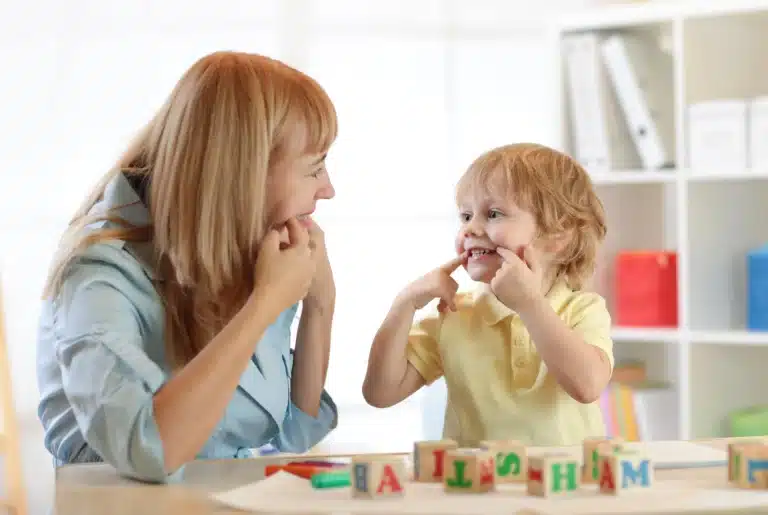 Speech therapist guiding a young child with a fun language-building activity, emphasizing speech and language skills.